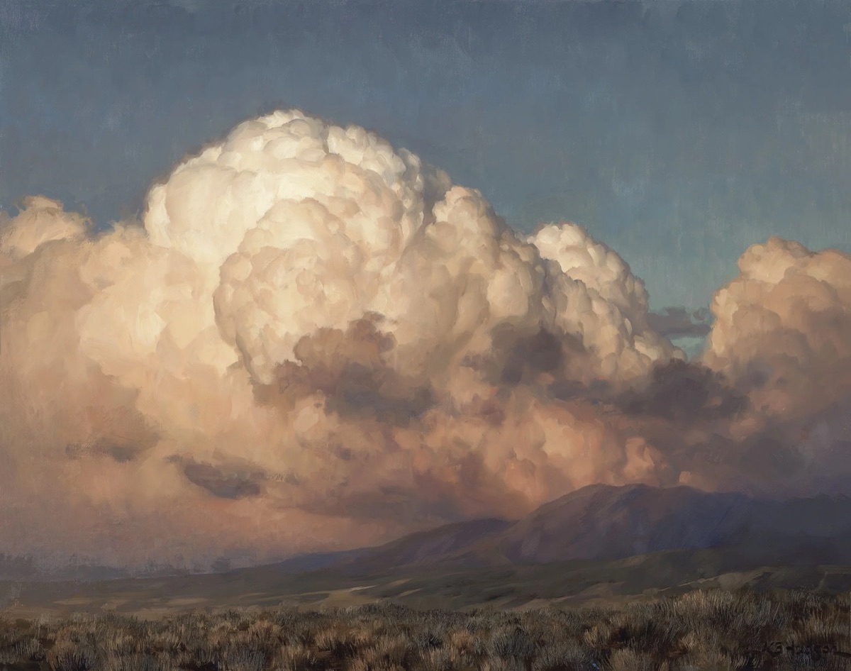 A tower of cumulus lit gold and rose by the setting sun, standing over a violet ridge and a wide flat of sagebrush.