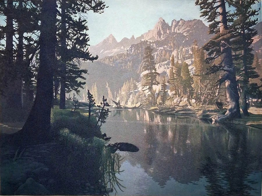 Dark conifers framing a still alpine lake in the Ansel Adams Wilderness, a jagged ridge catching the light behind it.